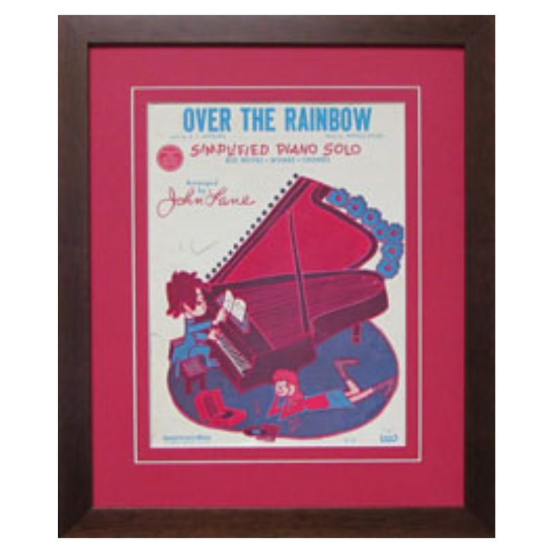 sheet music in a brown frame with red mat