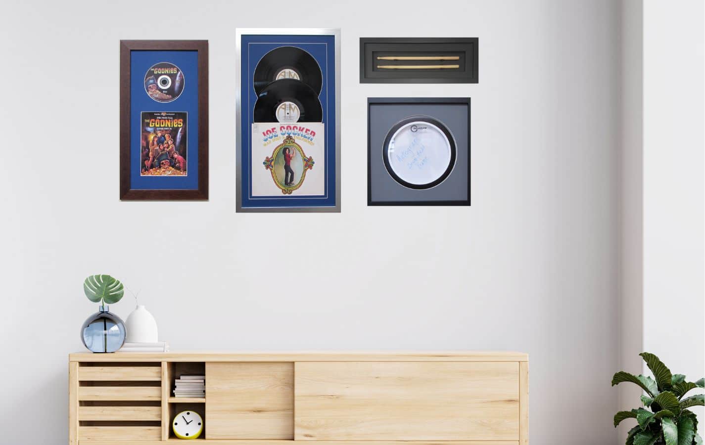 collage wall with framed record album, movie, drum head and sticks